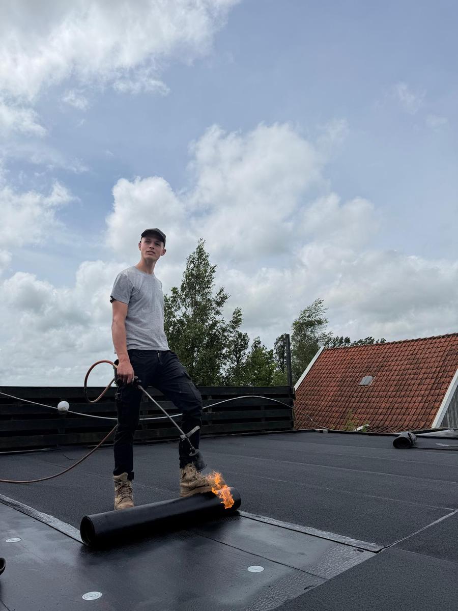 Dakdekker aan het werk met brander